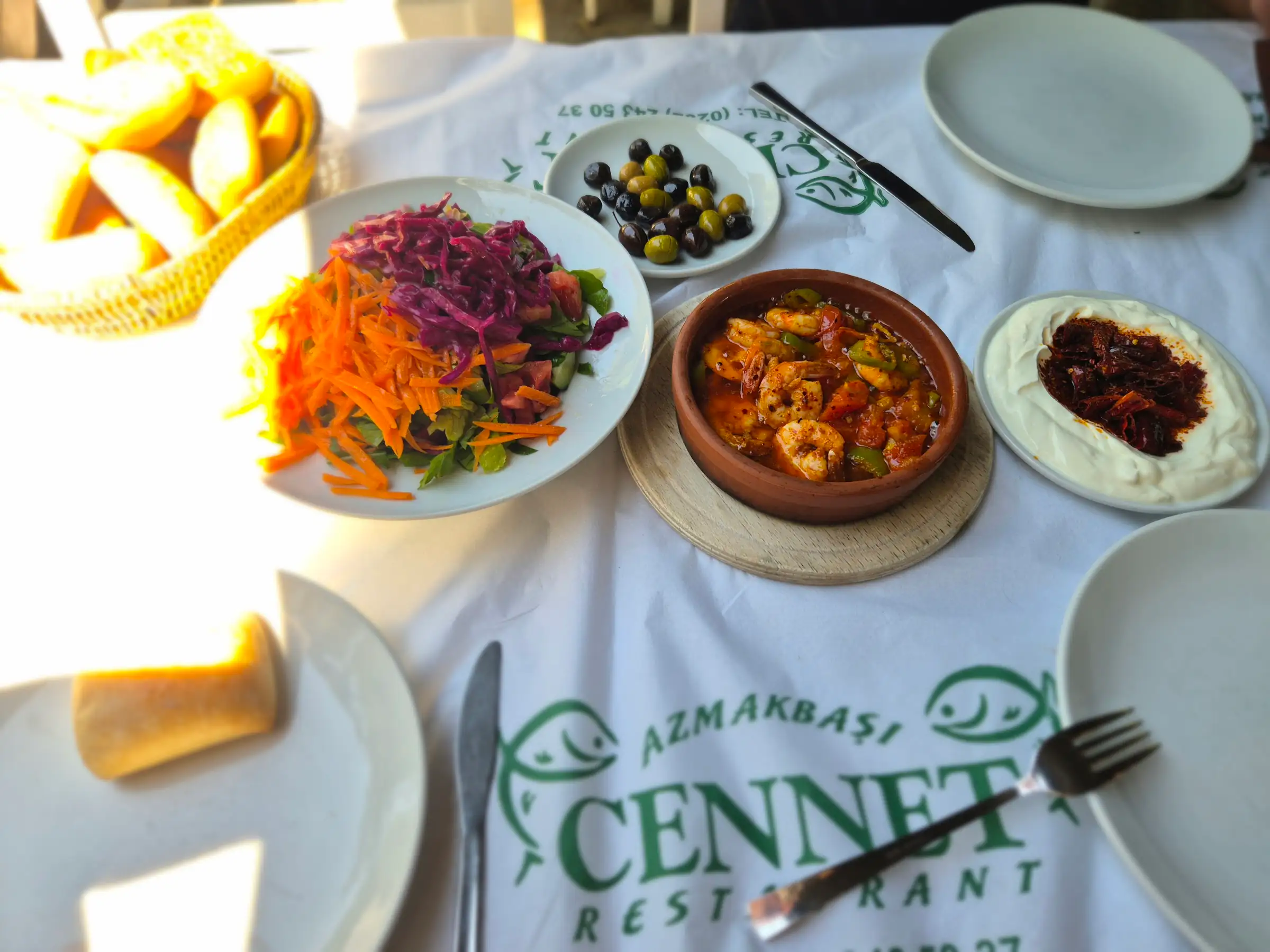 Cennet Restaurant örtüsü üzerinde zengin meze sofrası